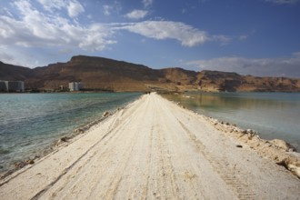 Sunset. Incredible lighting effects in a thunderstorm at the Dead Sea. The road in the middle of