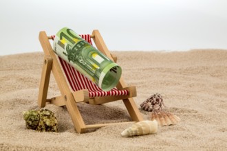 A deckchair with a euro banknote. Symbolic photo for saving on holiday and when travelling Austria