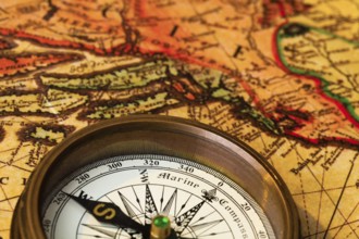 An old compass lies on a map of Austria