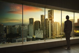 Geschäftsmann schauen und denken vor einem Fensterbüro mit moderner Stadt Skyline . Sunrise Szene