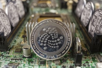 IOTA coin close-up on a computer circuit motherboard as a blockchain technology payment network.