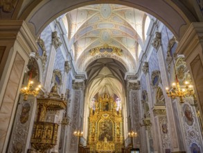 Magnificent interior of a baroque-style church with richly decorated altar and ceiling paintings