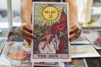 Close-up of the giant Tarot card The Sun held by the tarot reader