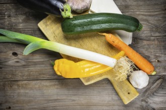Fresh vegetables ready for cooking shot on rustic wooden table