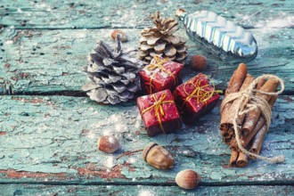 Christmas decorations, cone, cinnamon and nuts on wooden background