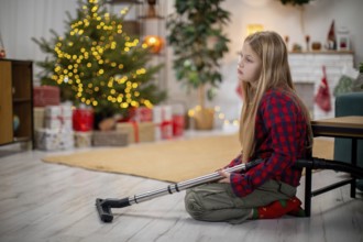 A thoughtful and reflective child who uses a crutch sits quietly beside a beautifully decorated