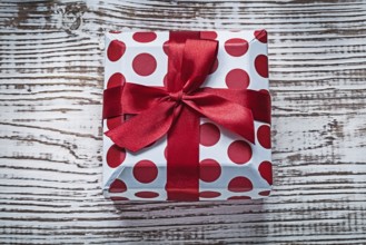 Present box with tied red bow on vintage wooden board celebrations concept