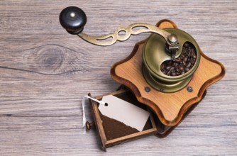 The photo shows an old coffee grinder on a wooden table