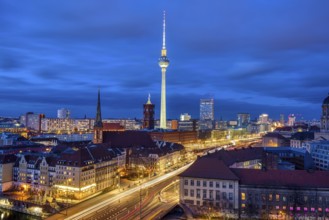 The centre of Berlin with the famous television tower and a cloudy sky at night