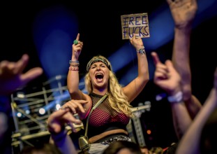 A female festival visitor with a sign at the Trailerpark concert with the inscription Free Fucks
