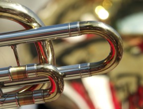 Abstract backgrounds of brass band instruments with details of a trombone in the foreground