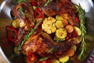Roasted chicken legs with various vegetables and spices