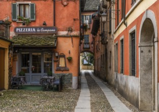 Orta San Giulio, Italy, 13 March, 2023: colorful shabby buildings in the old town center of Orta