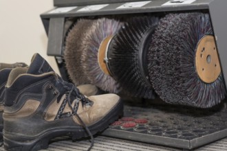Hiking boots stand by a shoe shine machine