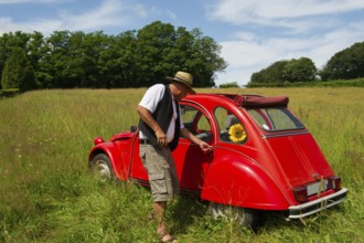 Typical French man is opening the door of his French car