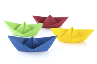 Colorful folded paper boats isolated over white background