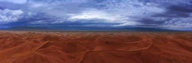 Aerial panorama view on sand dunes with storm clouds at sunset in Gobi Desert, Mongolia, Asia