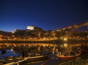 Old town river area of porto in portugal at night with rabelo boats