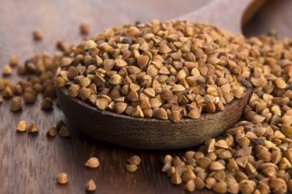 Buckwheat seeds on wooden spoon in closeup, lodz, poland