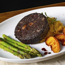 Black pudding with green asparagus and roasted apple