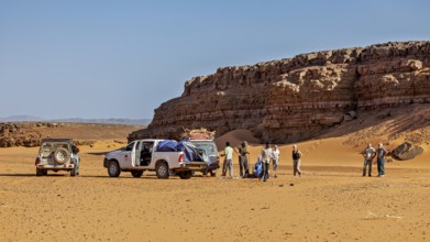 Off-road vehicle and people in a sunny desert landscape with impressive rock formations, Off-road