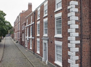 A street of elegant large brick 19th century houses in chester england with cobblestone pavement