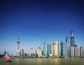 Shanghai pudong city skyline and local river ferry boat in china