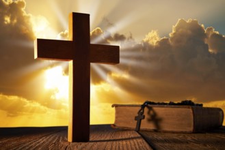 Christian wood cross on sunset sky wooden made with Bible and rosary beads