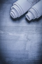 Vertical view two rolled white blueprints