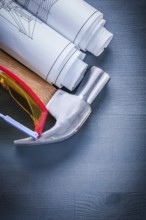 Vertical view rolled up blueprints hammer goggles