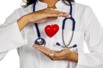 A young doctor (internist) symbolically holds a heart in her hand. Austria