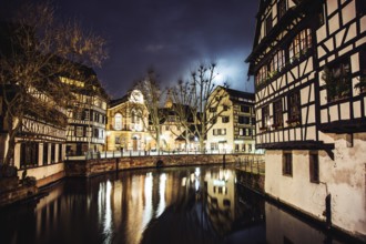 Scenic view View on river in Strasbourg, France at night. Romantic lights reflecting on the water