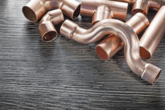 Plumbing copper water pipe fittings on wooden board