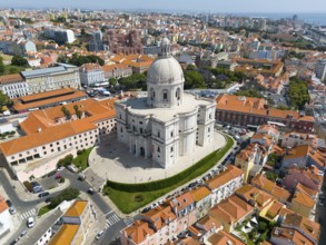 City view from above with central dominated dome-shaped structure surrounded by dense buildings,