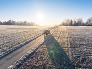 An SUV drives along a frosty country road in the winter morning light, Car Sharing, Electric car,