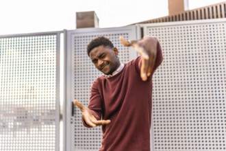 Cool urban dancer gesturing and winking to the camera while dancing in the city