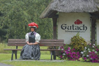 Doll in woman's traditional costume with Bollenhut on bench, Black Forest, Bollenhut, clothing,