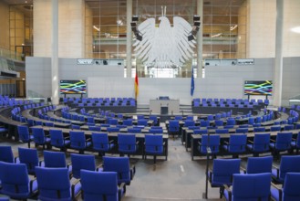 The plenary chamber of the Bundestag with many blue seats and the German flag, Reichstag building,