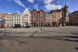 Row of historic buildings, brick buildings, gables, blue sky with cumulus clouds, street An der
