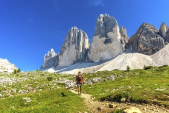 Tourist enjoying a summer hike on a scenic trail leading to the majestic tre cime di lavaredo peaks