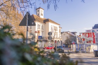 Historic town hall in the old town centre, surrounded by street signs and building fences in sunny