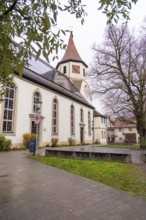 Old church surrounded by trees, well-kept pavement in the foreground, quiet atmosphere,