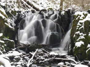 Teufelsmühle waterfall on the hill stream the Schwartzbach, in snow and ice in November. The Rhön