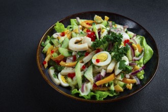 Salad with squid, fresh cucumber, eggs, sweet pepper, red onion, with dressing, homemade, no people