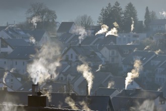 Smoke rising from the chimneys of a housing estate at dawn, Korb im Remstal, Baden-Württemberg,