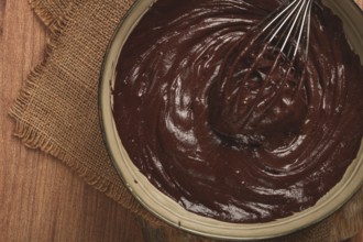A bowl of chocolate dough, a whisk for whipping, baking, structure and consistency, homemade, top