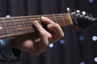 Image of the hands of a musician playing the electric guitar. The concept of concerts and
