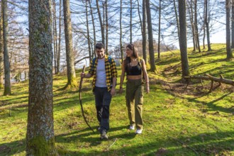 Hikers savoring a sunny day while walking along a scenic forest trail, surrounded by vibrant trees