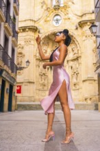 Beautiful Dominican ethnic girl with braids with a beautiful pink dress. Fashion enjoying summer in