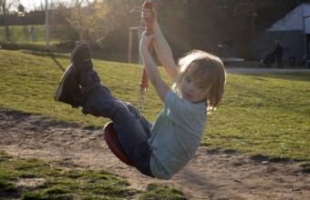 Little boy, 5 years, blond, playground, rides with cable car, backlight, playground, Stuttgart,